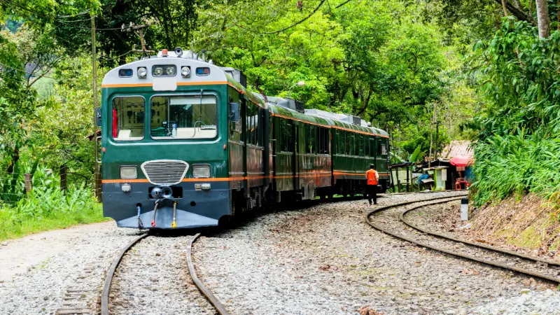 Tourist train to Machu Picchu through the greenery of the Urubamba valley