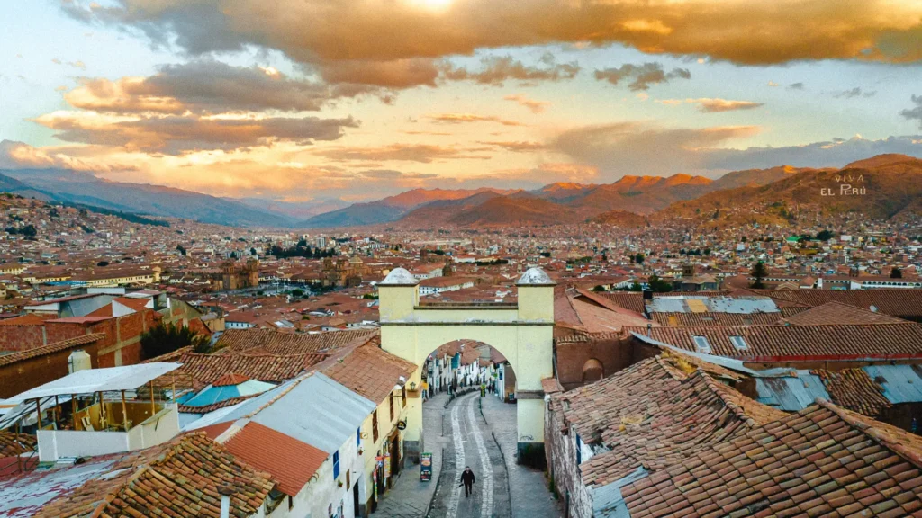 Telhados de Cusco e um arco colonial ao entardecer