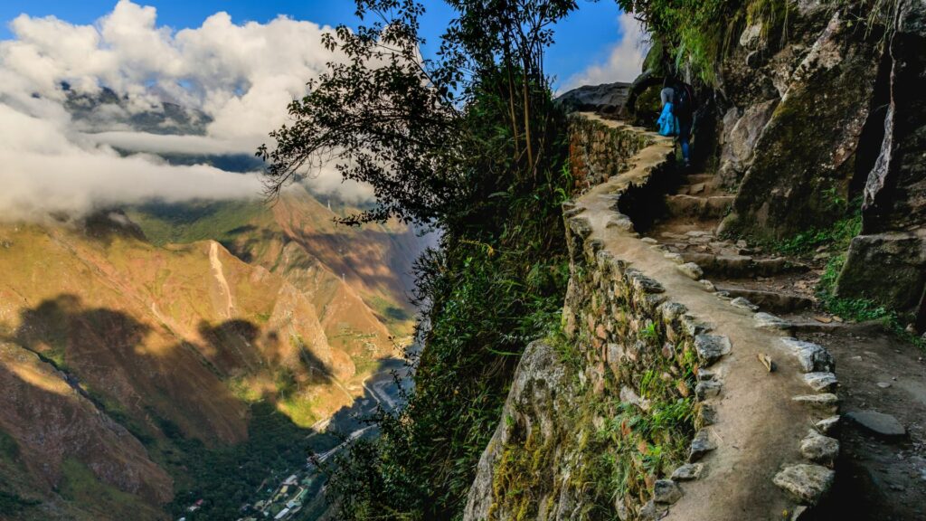 Hikers at the Machu Picchu, Cusco, enjoying a vast view of the Andean valley and ancient Inca terraces.