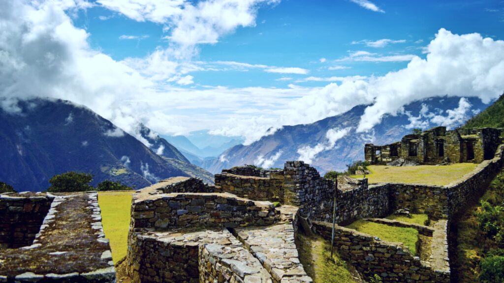 Ancient stone structures and terraces of Choquequirao covered in mist.