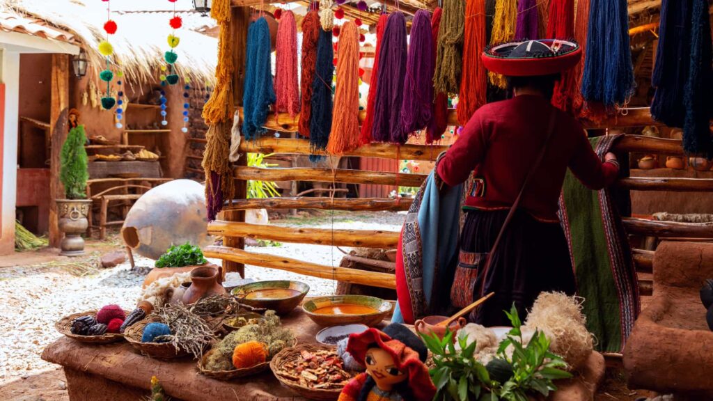 Tejedora andina en un puesto de textiles y artesanías
